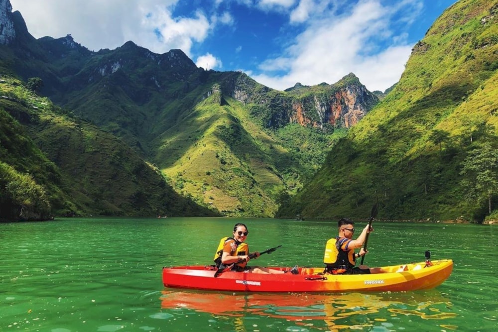 Experience the thrill of kayaking through the stunning emerald waters of the Nho Que River 